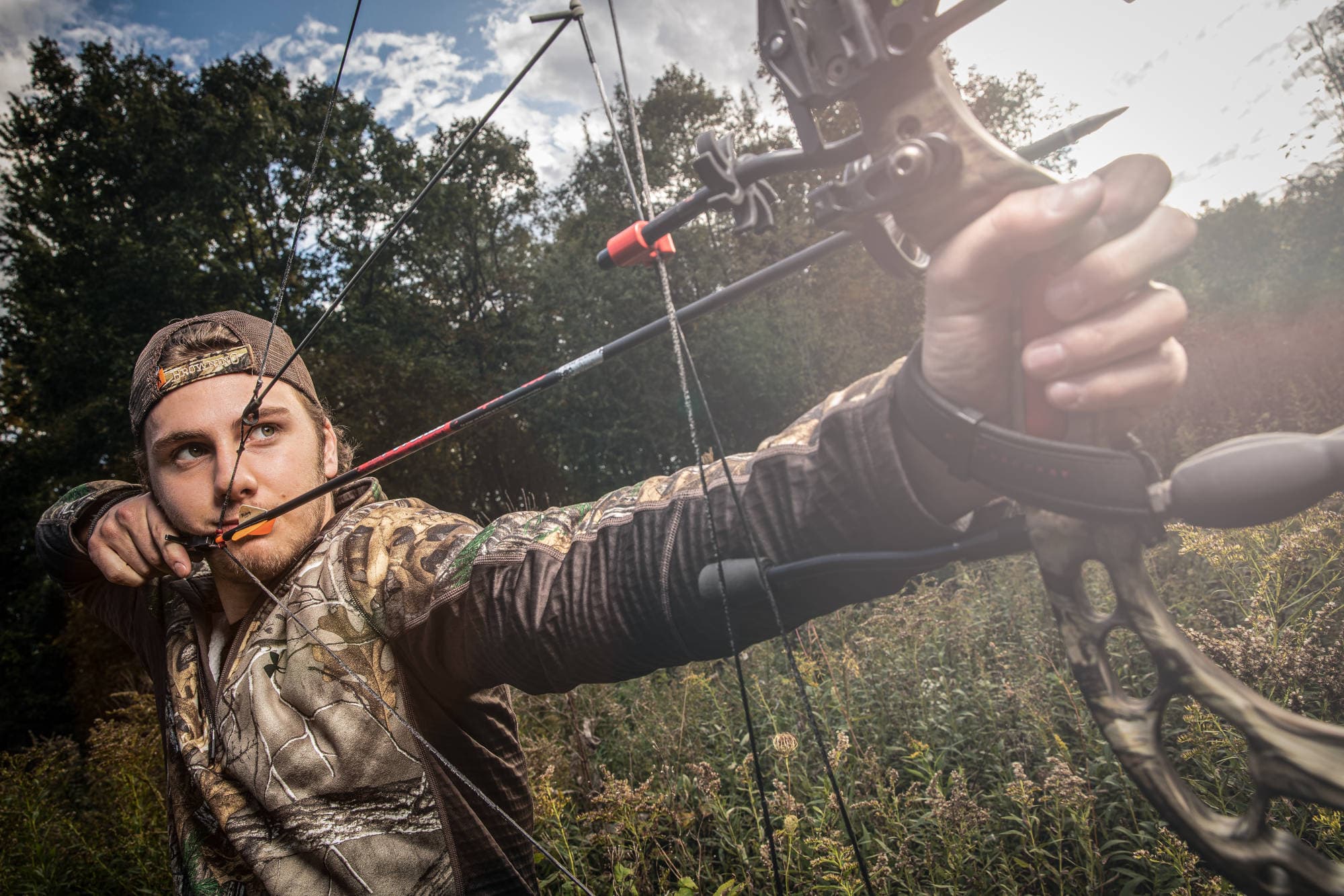 Archer drawing a bow outdoors
